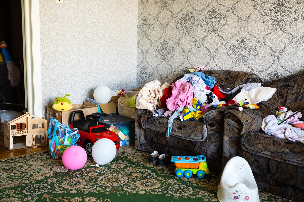 An old couch in room with rubbish all over.