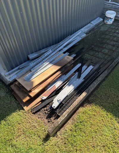 Timber beams laying next to backyard shed